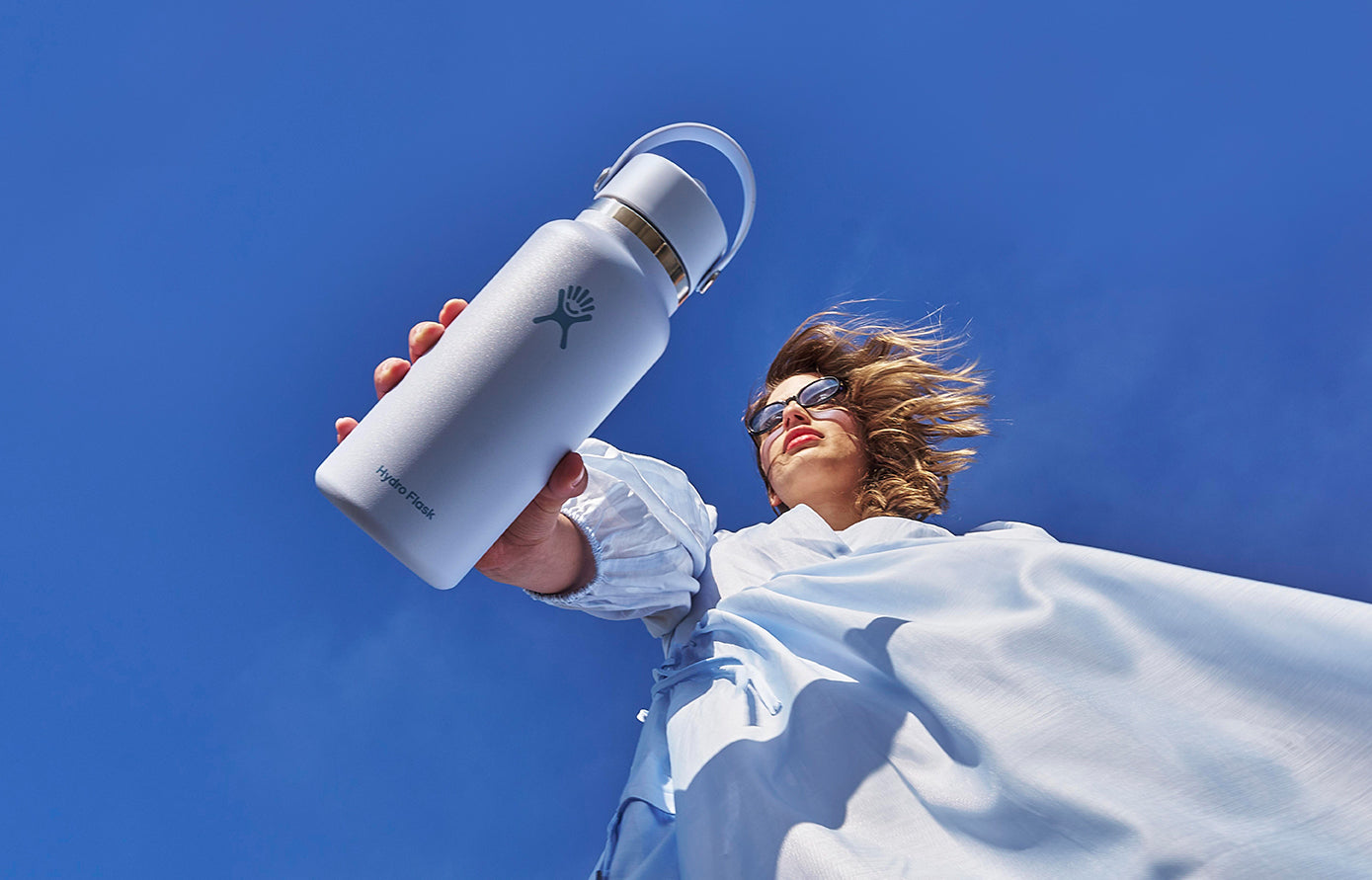 Woman holding a white Hydro Flask bottle outdoors